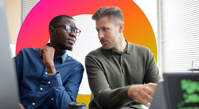 Two people collaborate together on a laptop